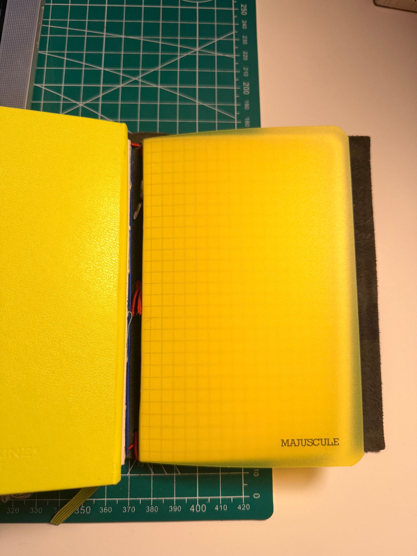 yellow translucent majuscule notebook open on cutting mat