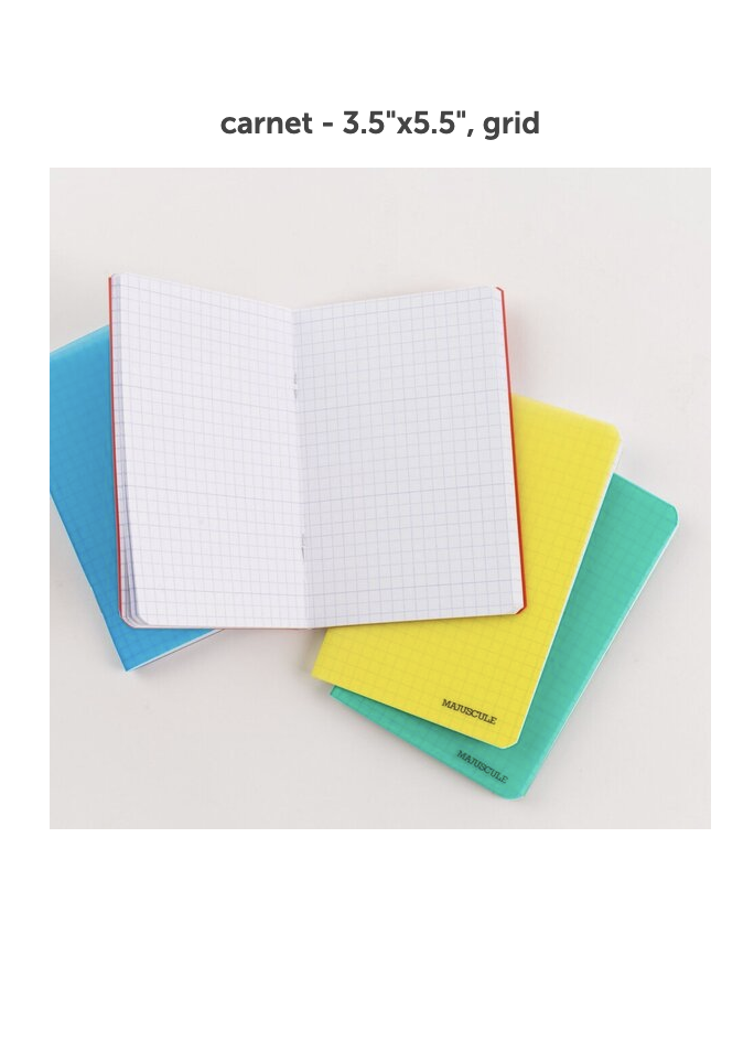 stack of translucent majuscule carnet notebooks in blue, yellow, and green