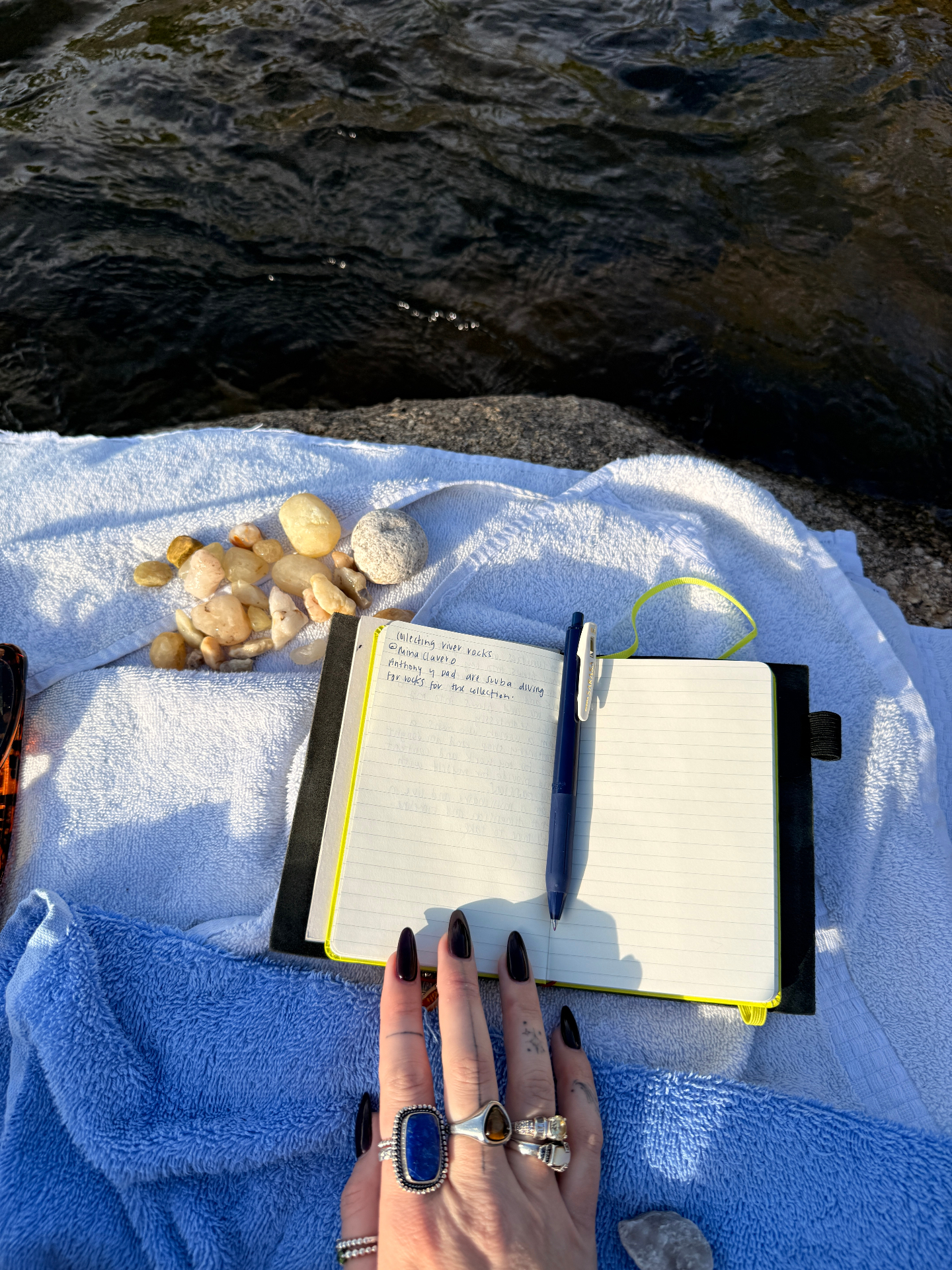 lime green moleskin open by the river with rocks