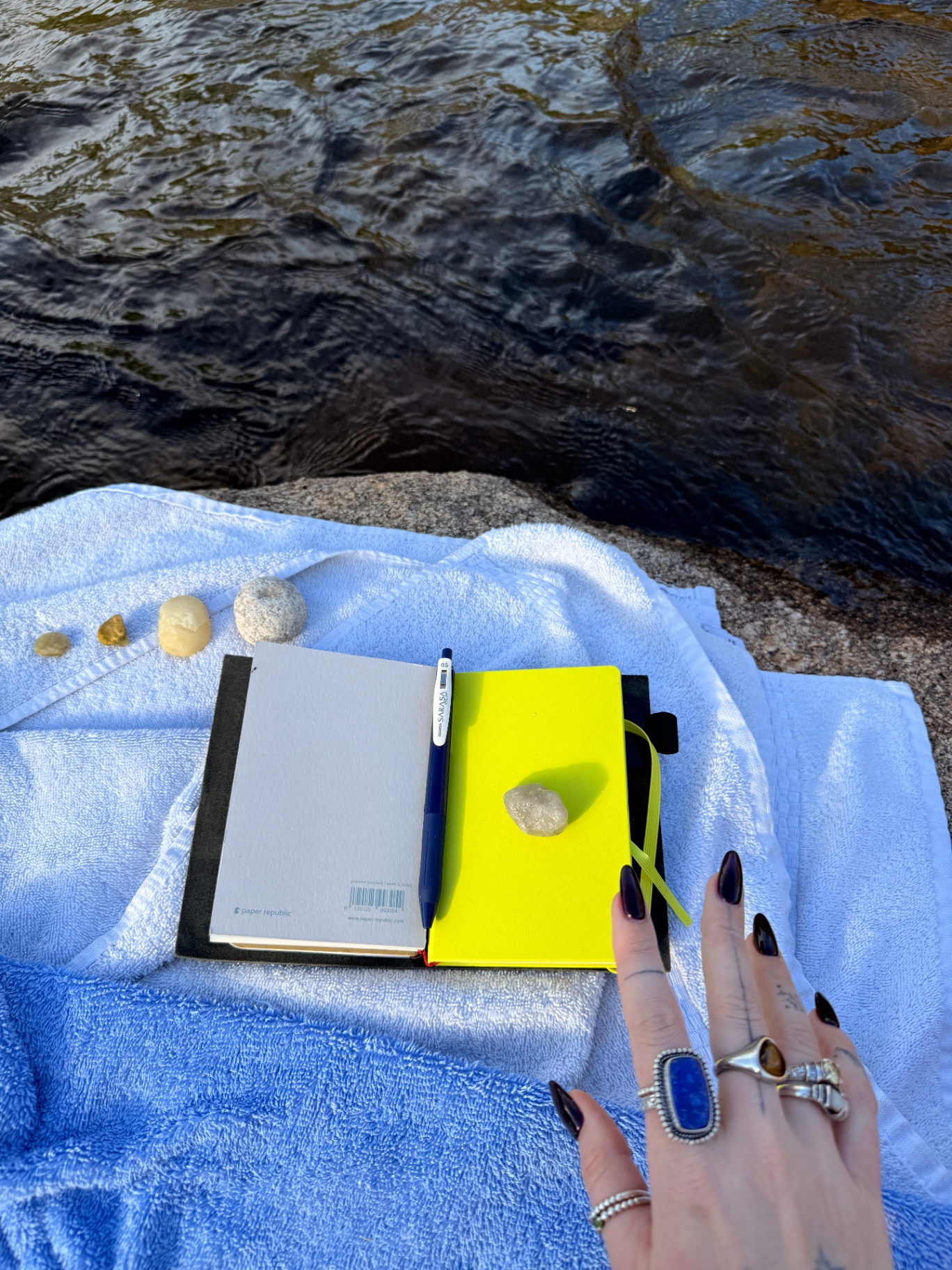 lime green moleskin by the water with rings and rocks