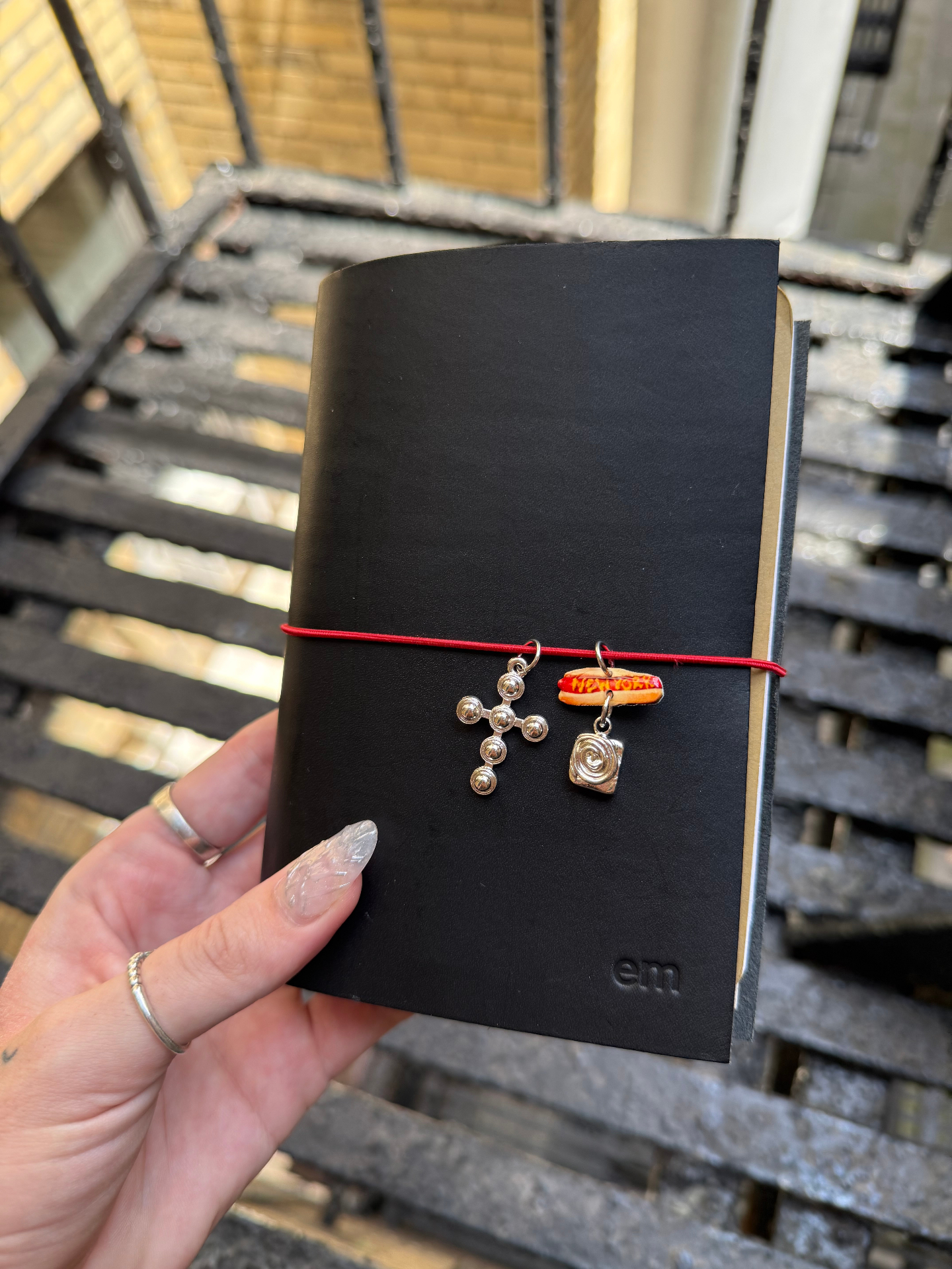 pocket journal held up with charms on the elastic