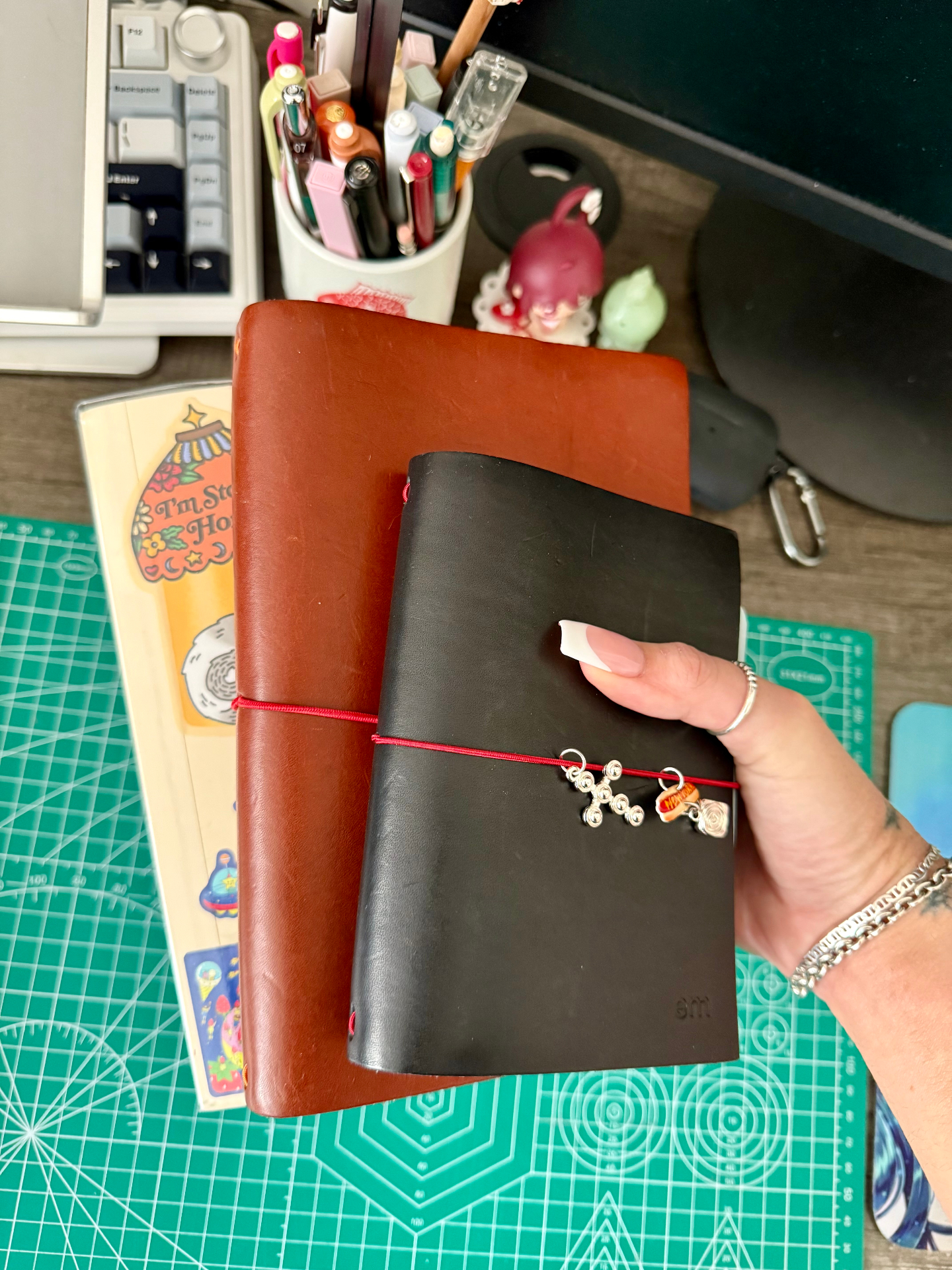 black pocket journal stacked on a brown leather journal
